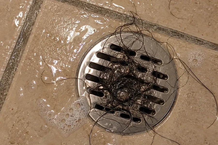 Pelo atorado en la coladera de la regadera